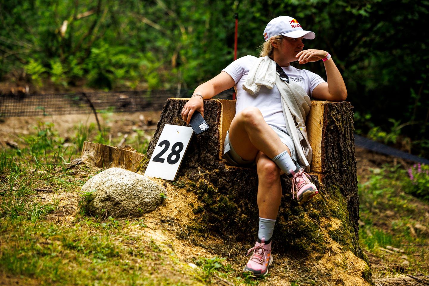 Vali sitting in a tree stump during the track walk in Val di Sole, Italy.