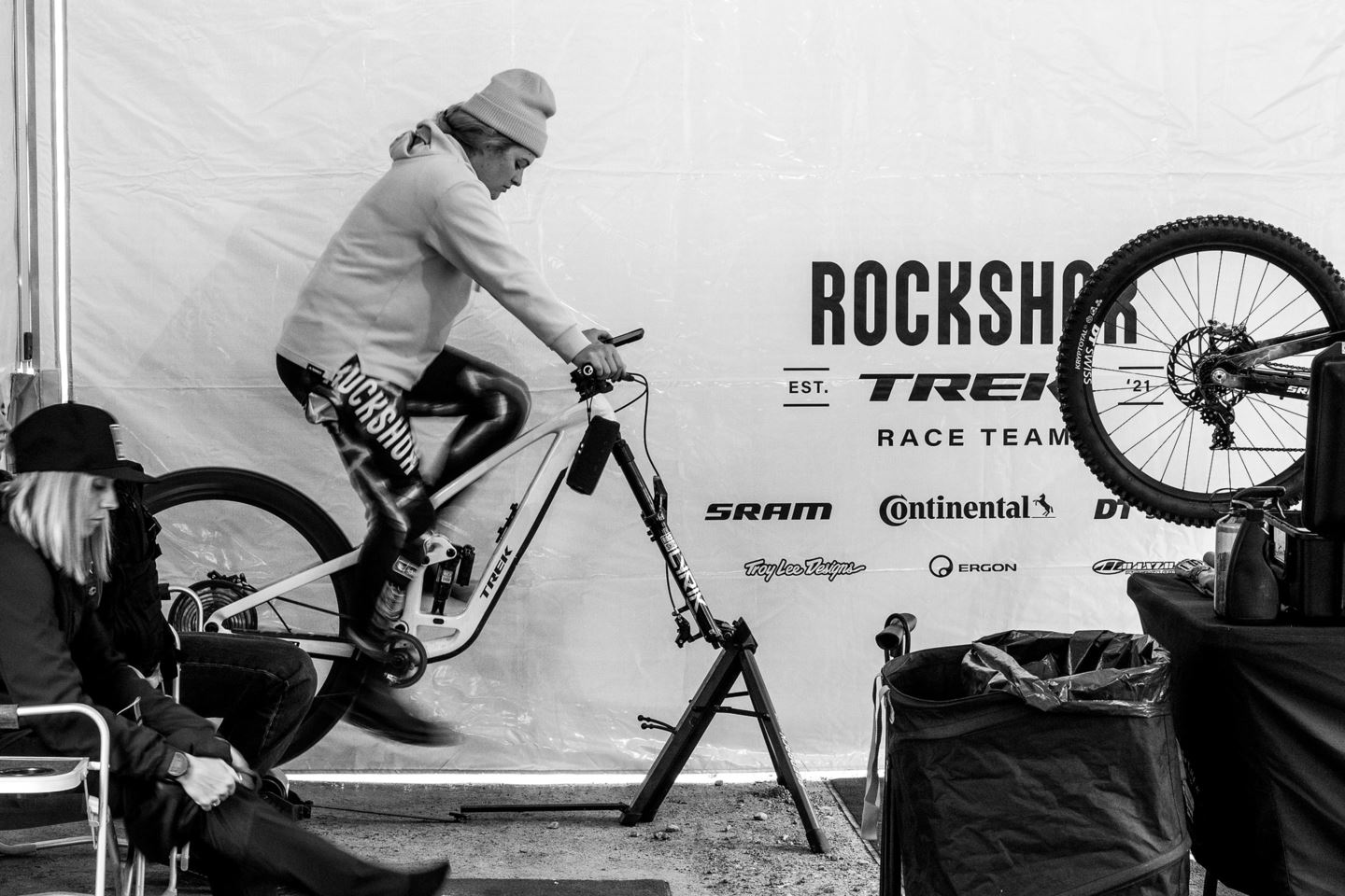 A black and white photo of Vali warming up on her trainer in the team tent.