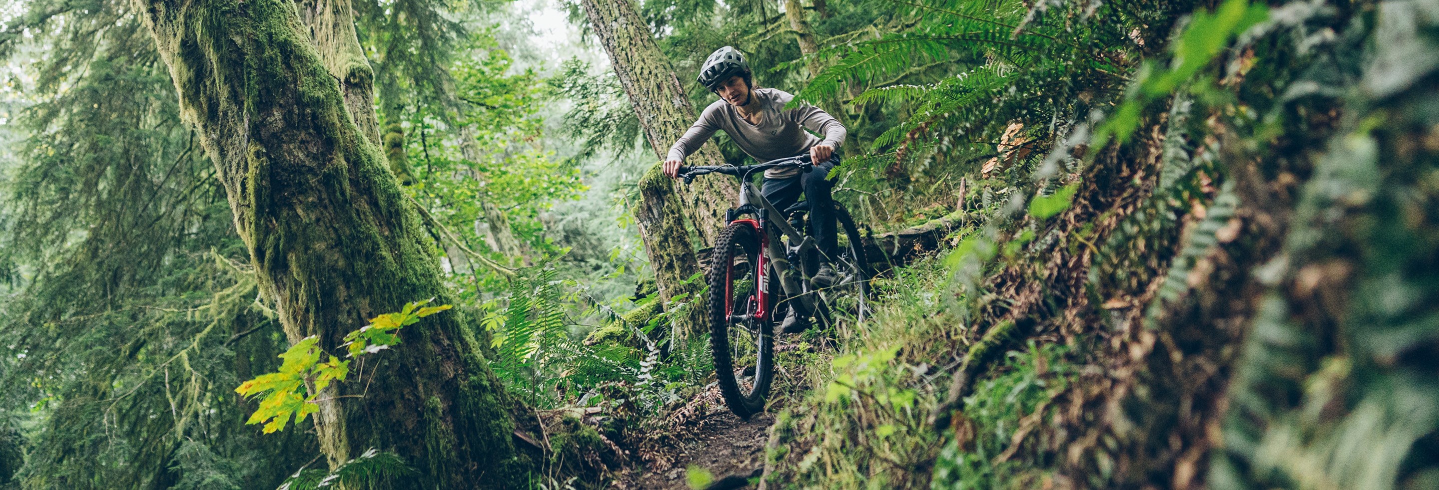 Trail rider riding steep descent on RockShox Deluxe equipped Transition Smuggler