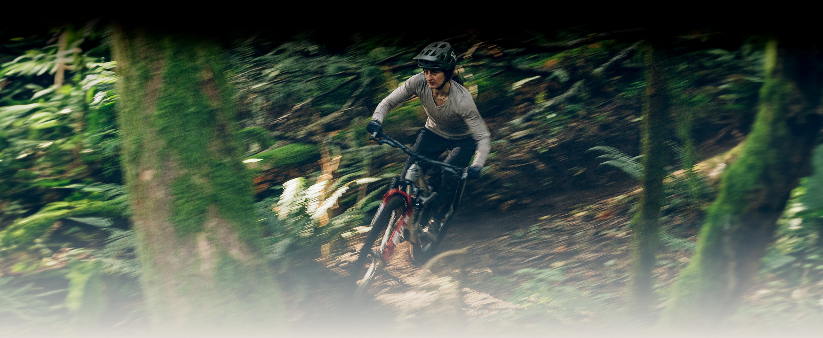 Rider descending steep loamy trail with RockShox Flight Attendant Electric Red fork on Transition Smuggler
