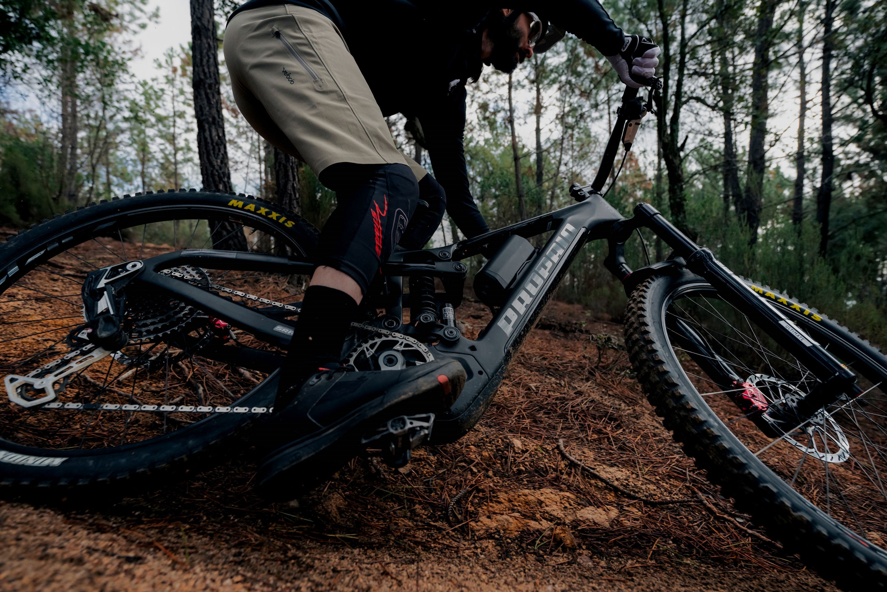 profile shot of a MTB rider sliding through some mud