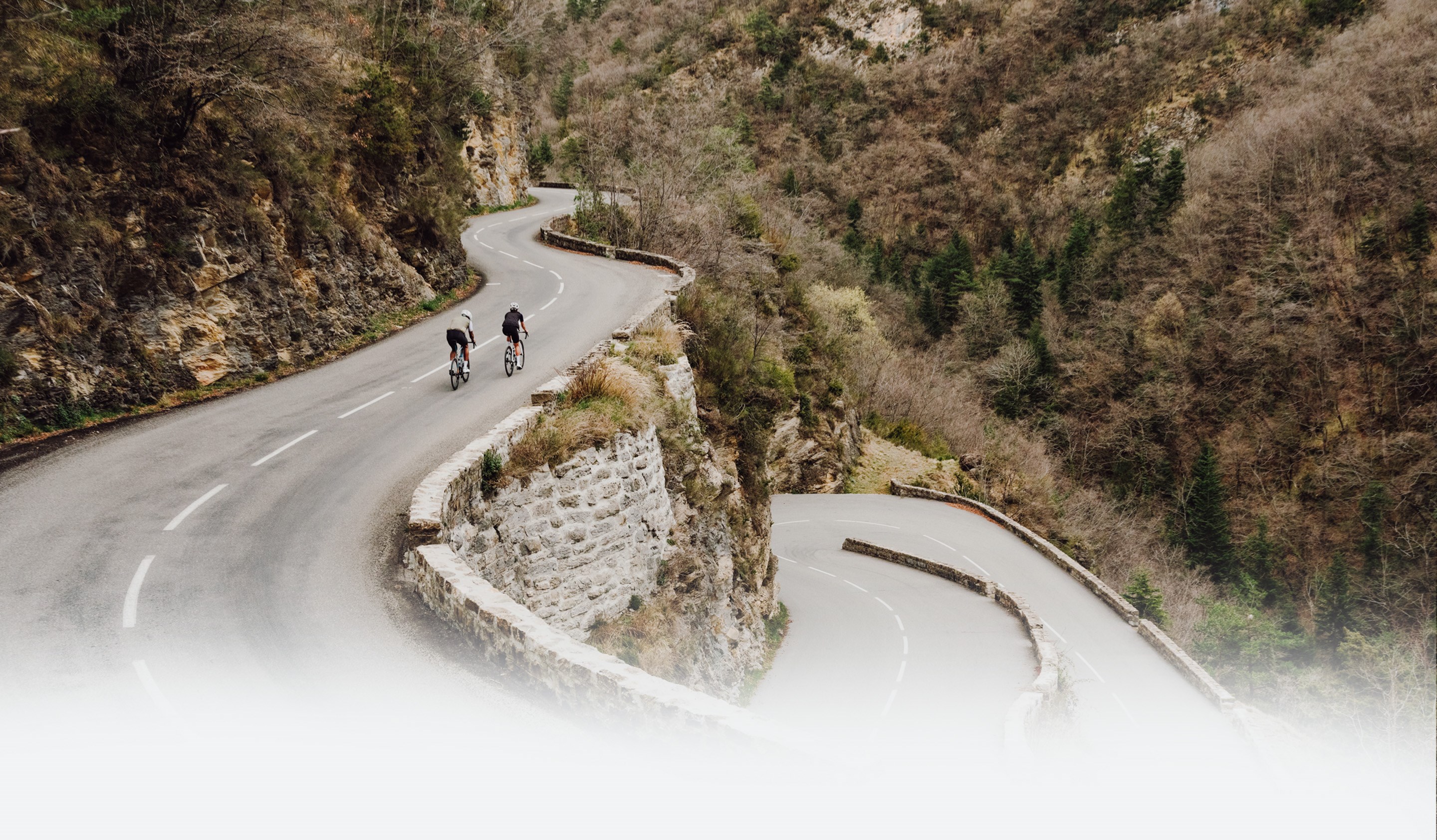 Two cyclists effortlessly pedaling their SRAM Rival equipped bike up a steep hill climb