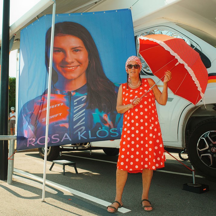 Rosa Klöser's mother standing next to printed sign of Rosa on RV