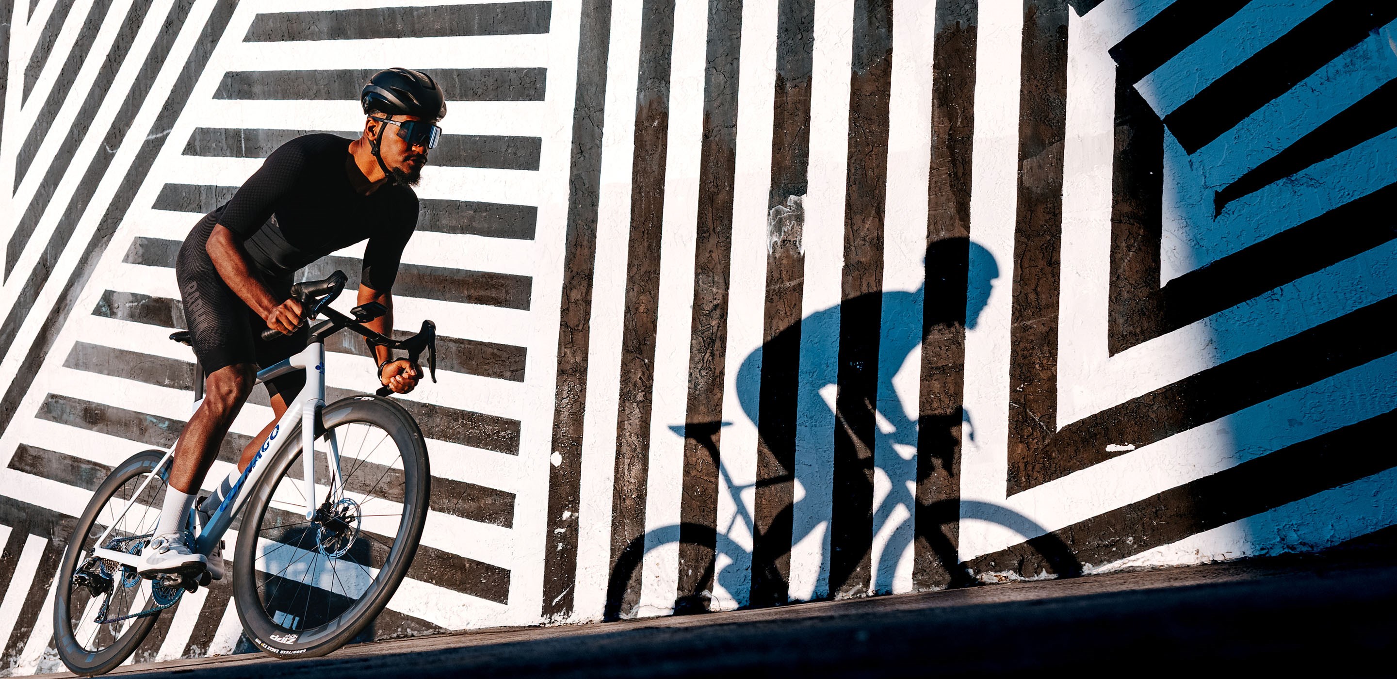 Rider on Zipp 404 S wheels riding infront of an abstract mural in Miami FL
