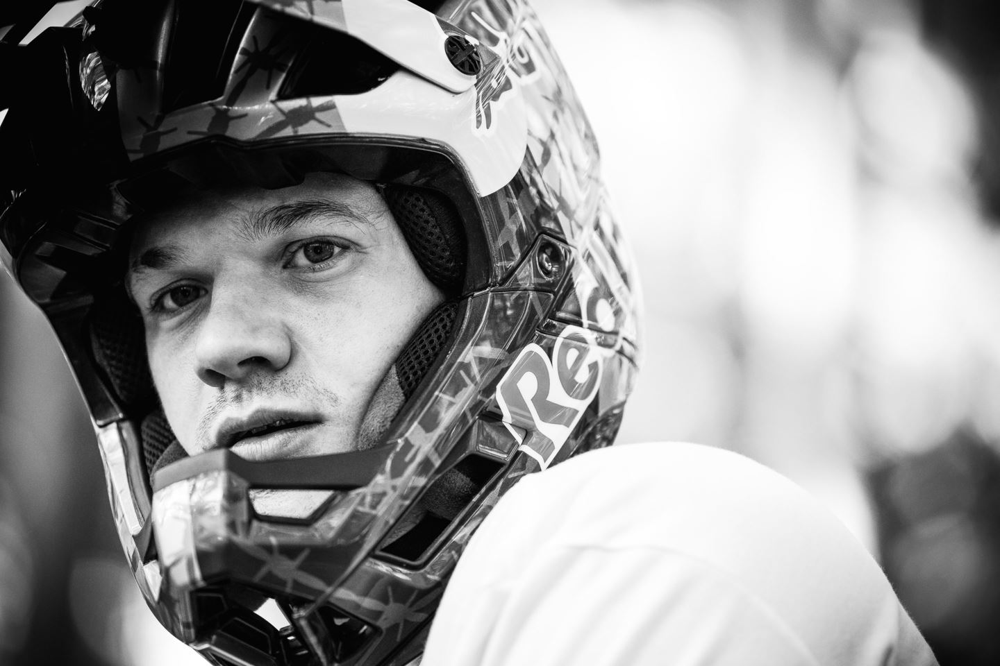 A black and white portrait of Kade Edward with his Red Bull full-face helmet on.