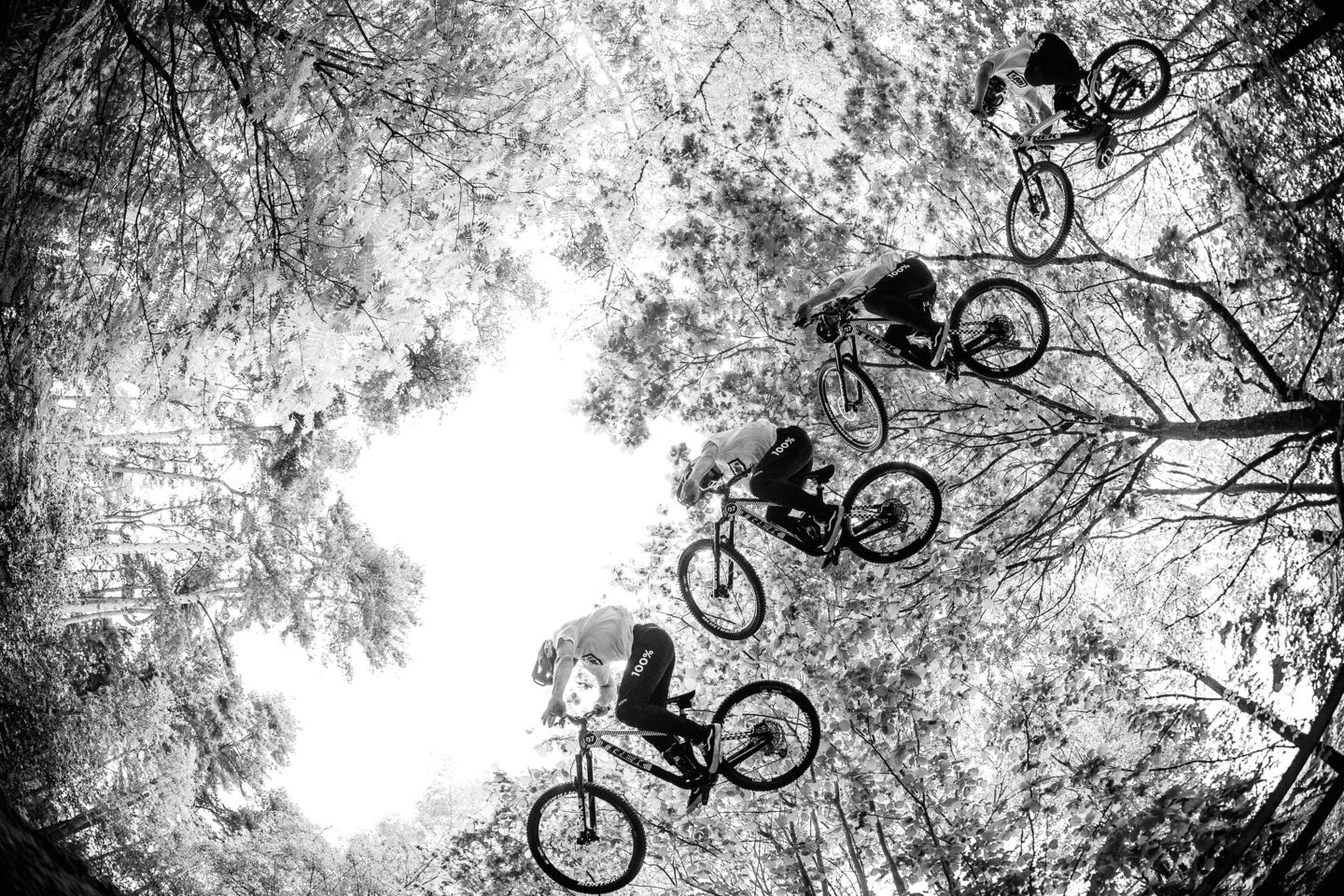 A black and white photo of Kade Edwards doing a trick above the camera.
