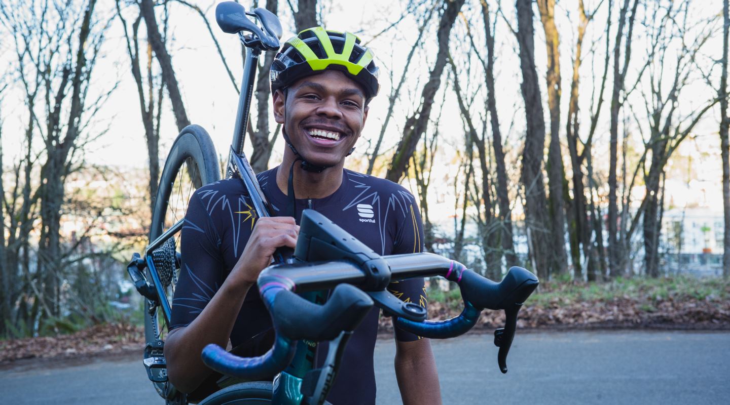 Trevon smiling and holding his bike.