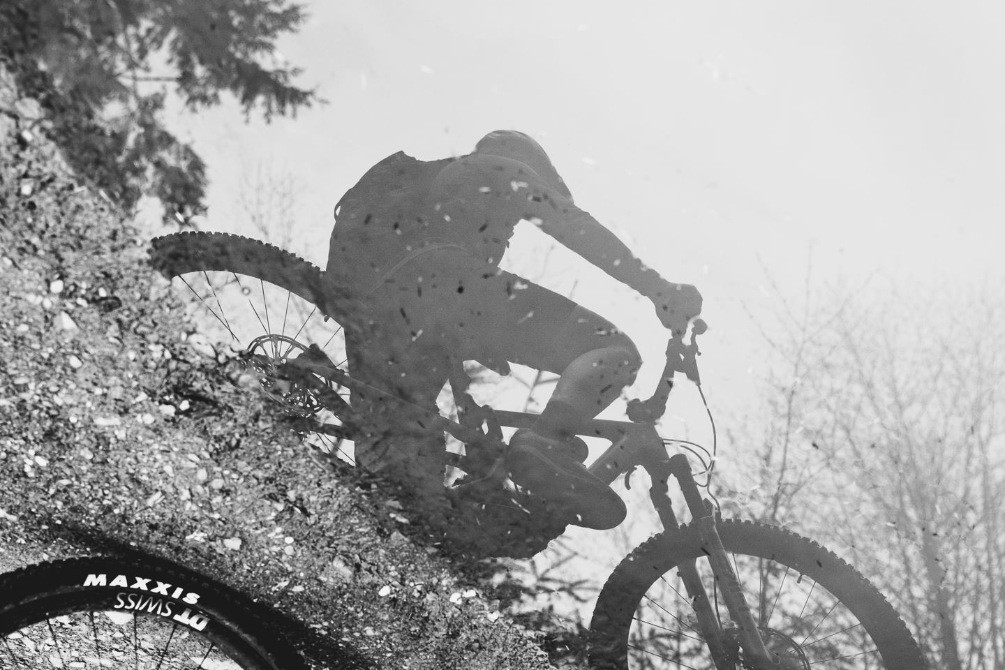 B&W photo of Britt Phelan's reflection in a puddle.