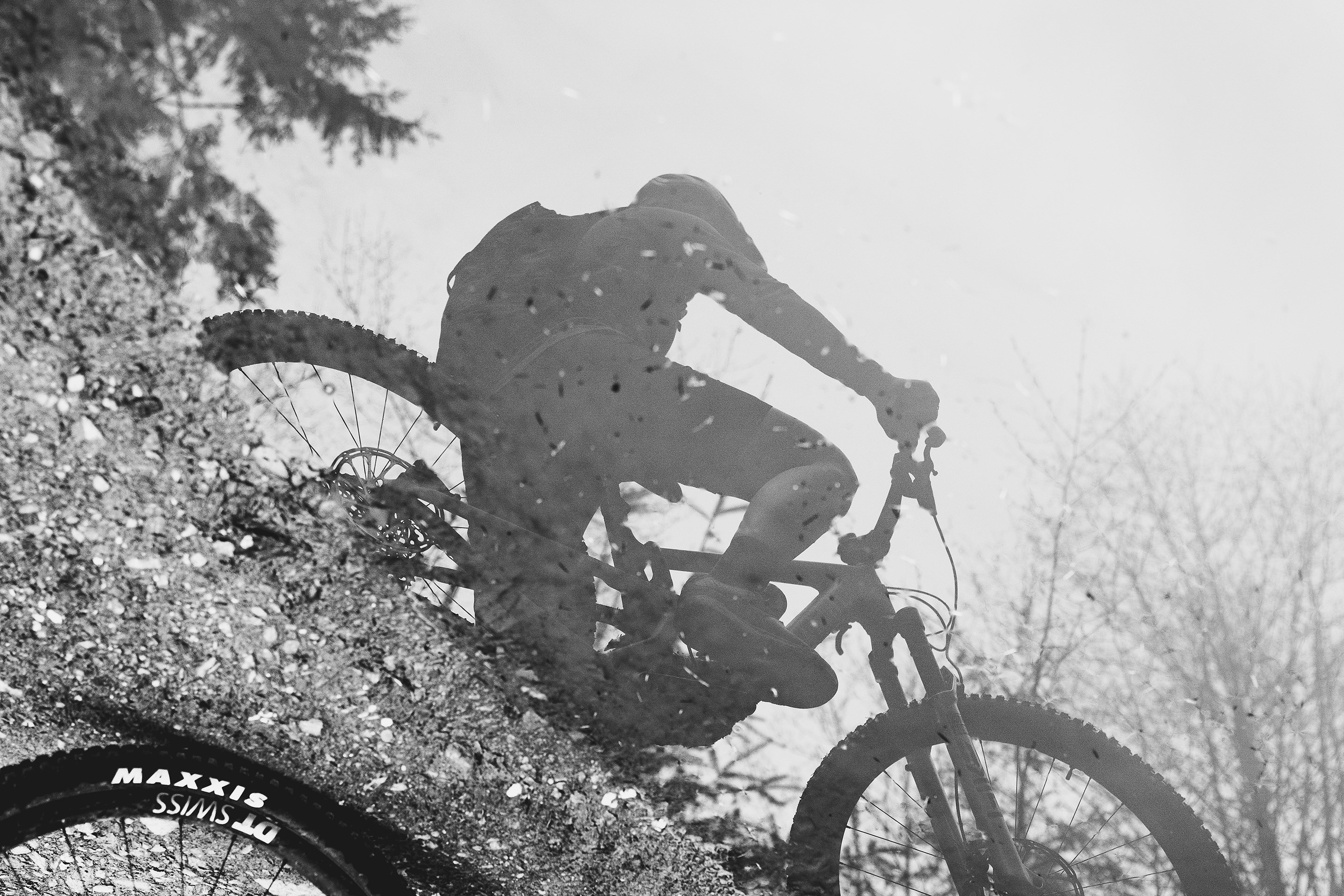 B&W photo of Britt Phelan's reflection in a puddle.