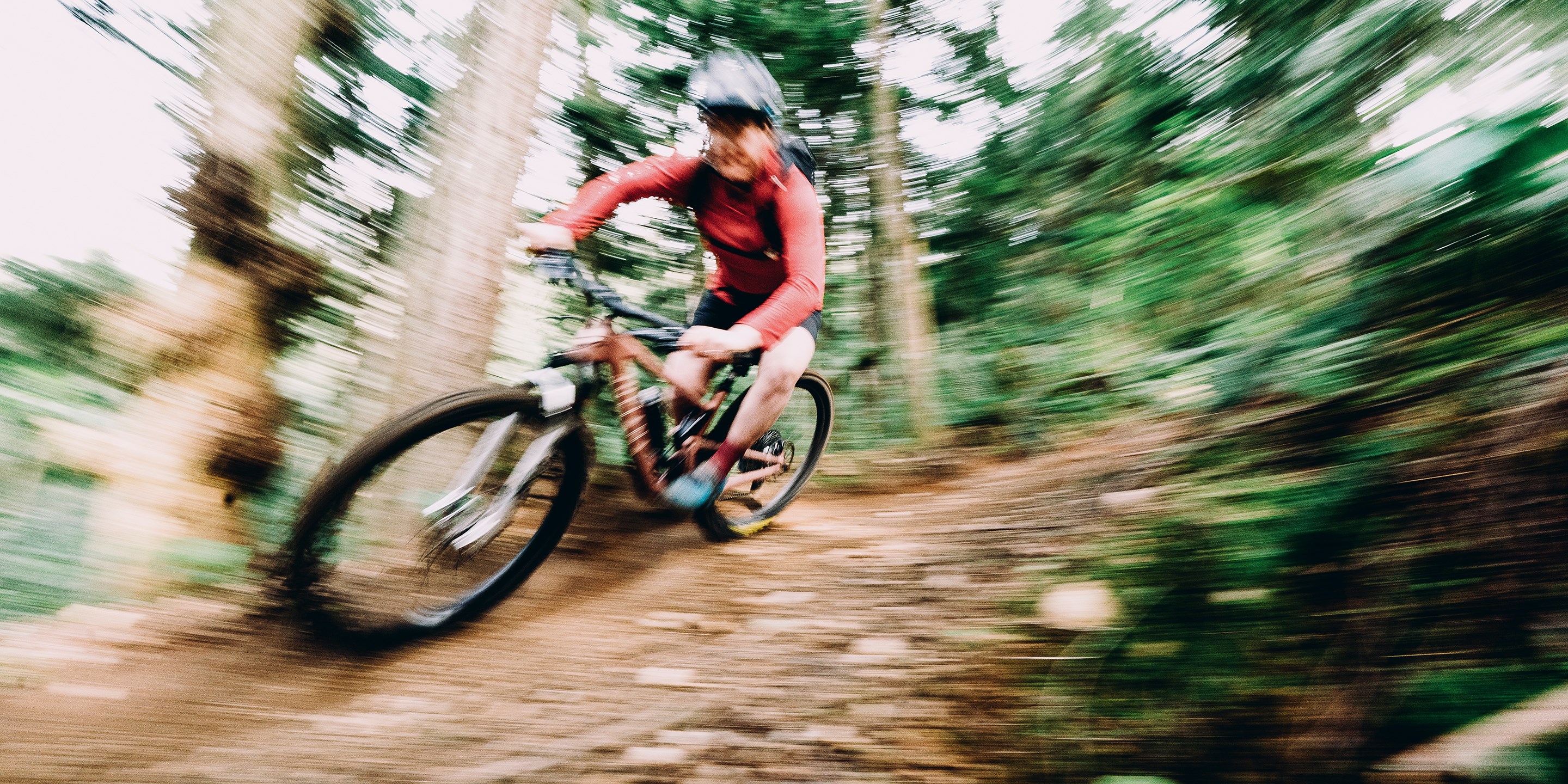 Pan shot of Britt Phelan barreling down a trail.