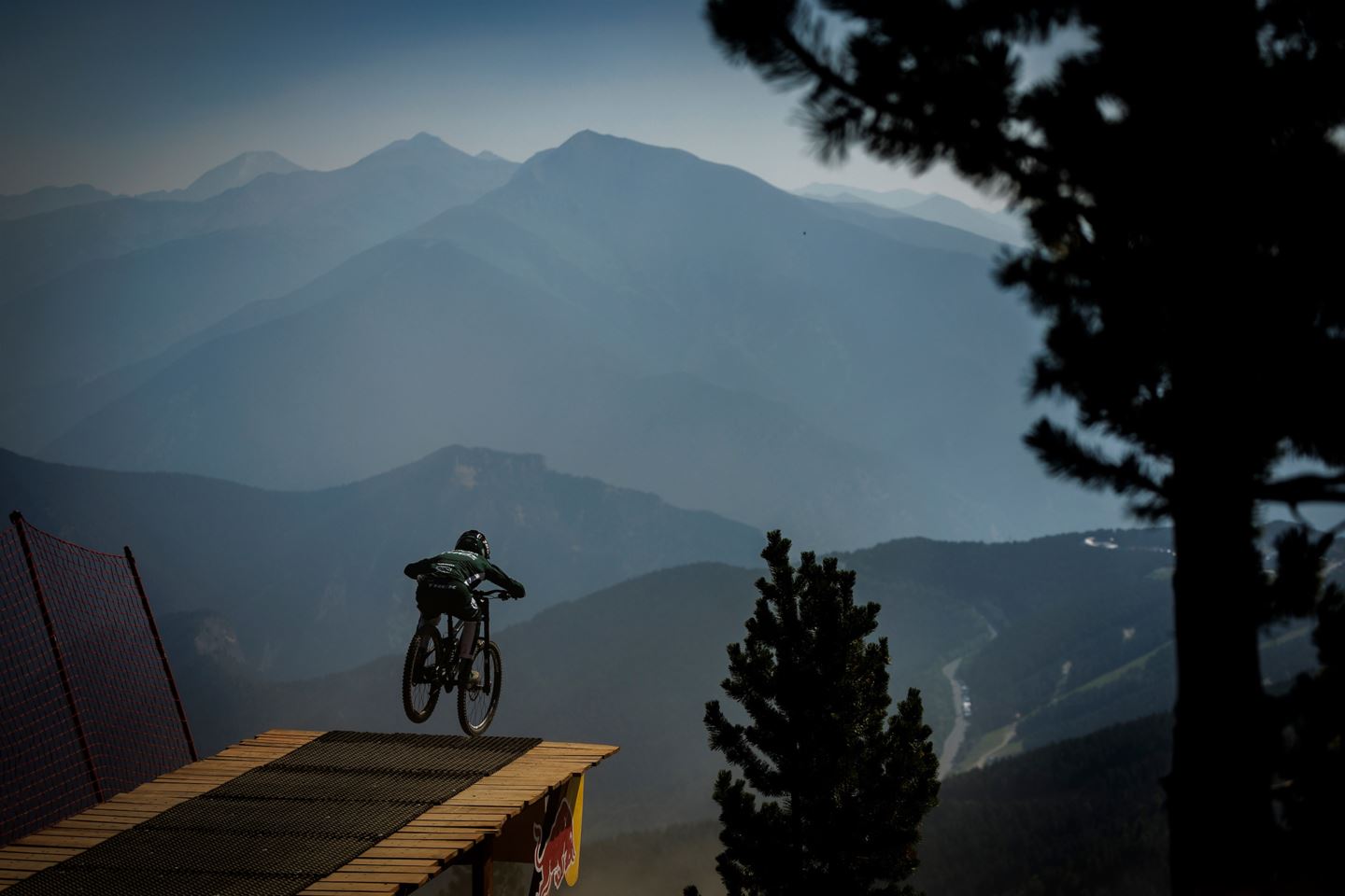 Loris Vergier going off of the Red Bull Big Jump with the. Pyrenees in the background.