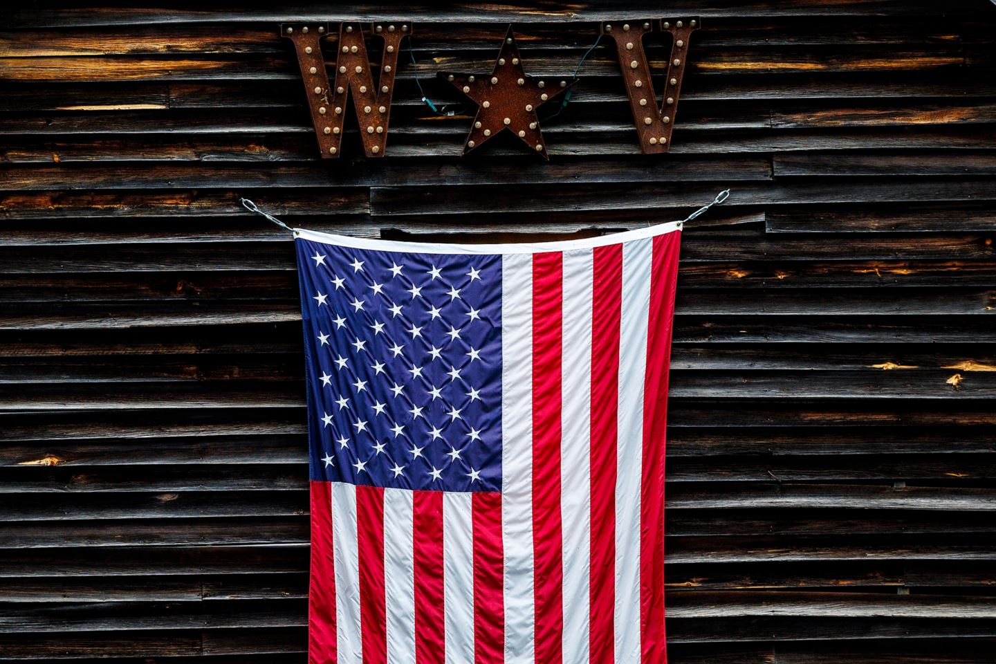 American flag hanging in front of a wooden cabin in Snowshoe, West VIrginia.