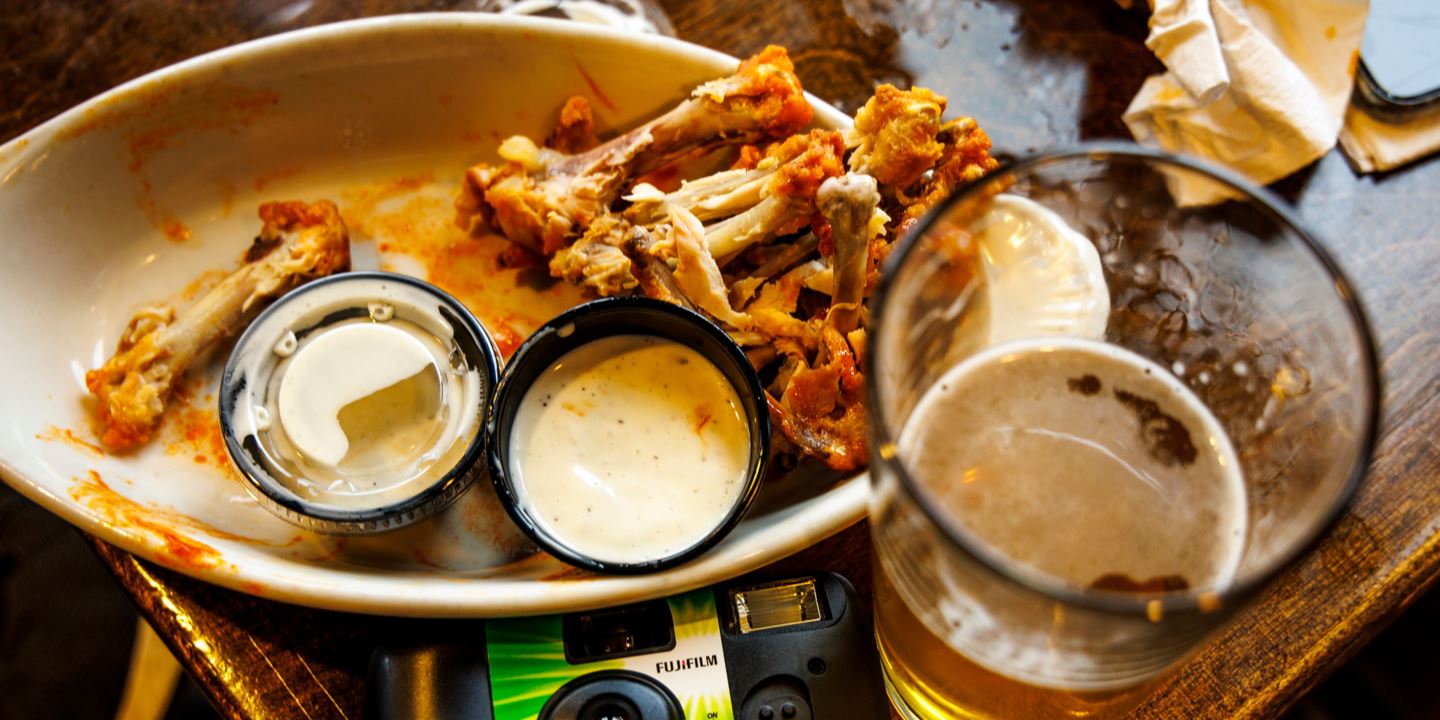 Plate full of chicken wing bones, beer and disposal camera in Snowshoe, West Virginia.