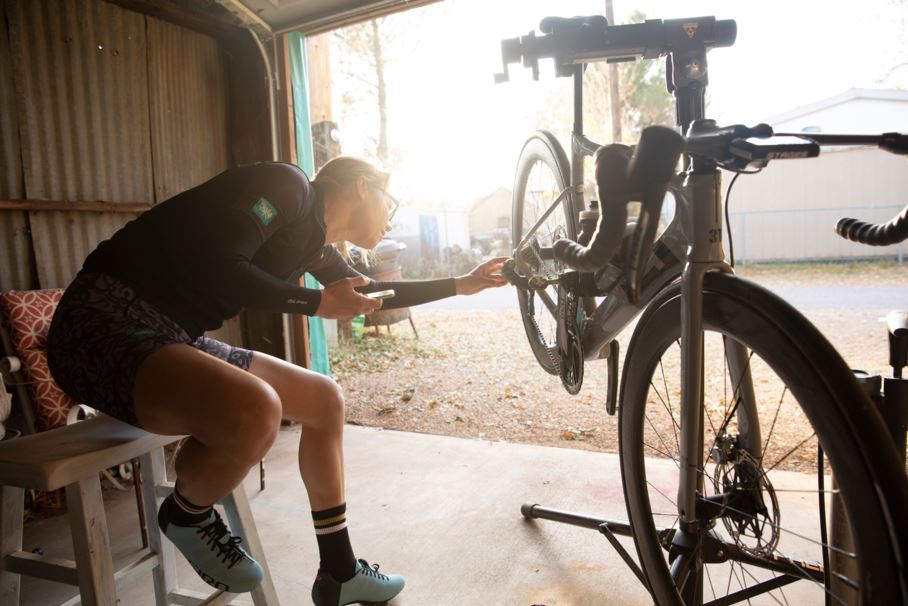 woman adjusting rear derailleur on a bike