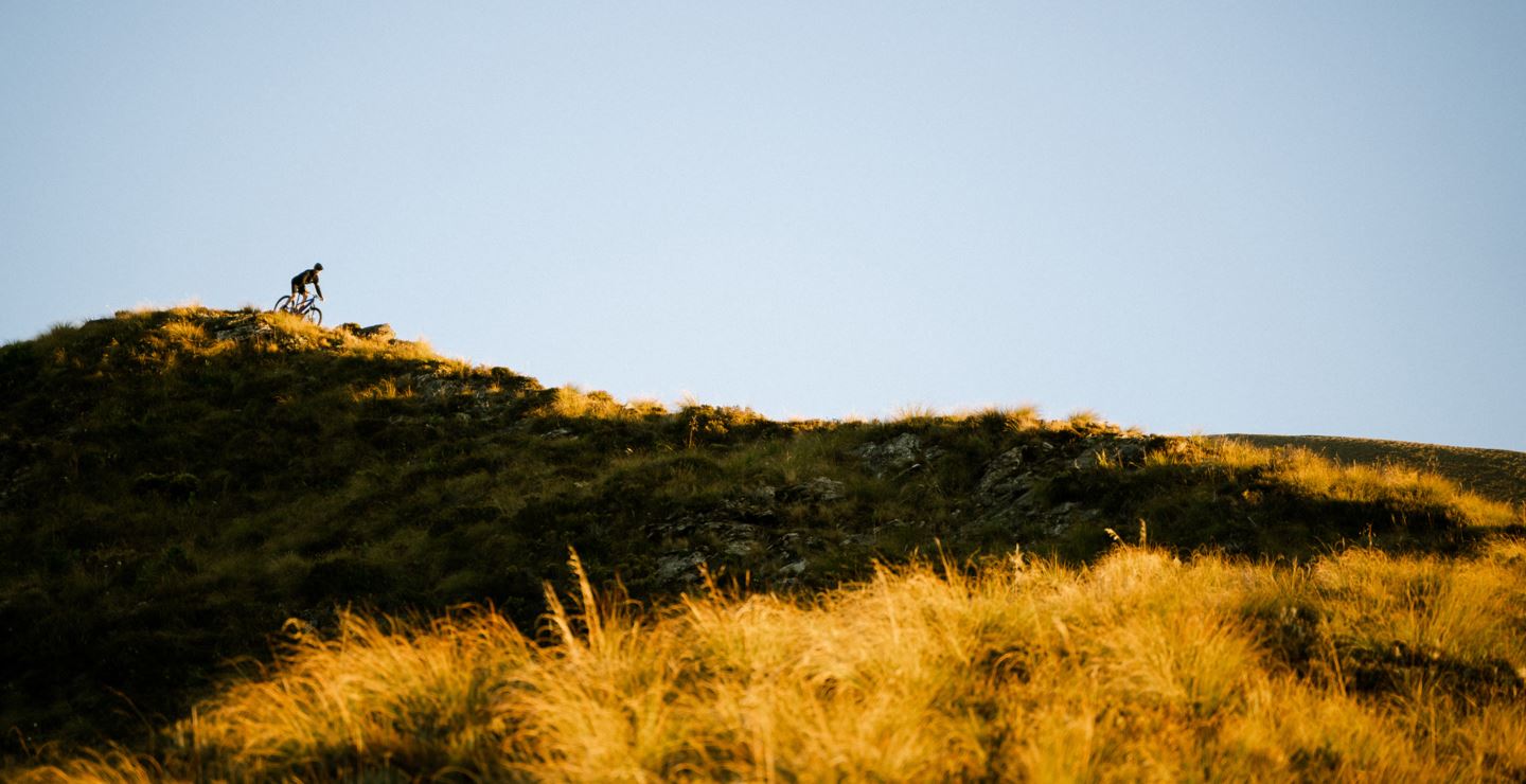 Riding down an alpine ridge in soft morning light