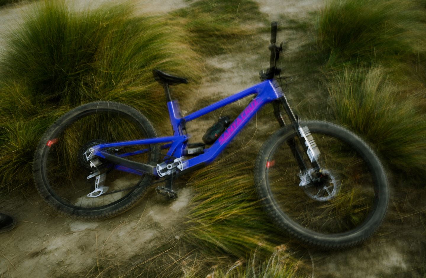 ben Hildreds blue mountain bike laying in grass
