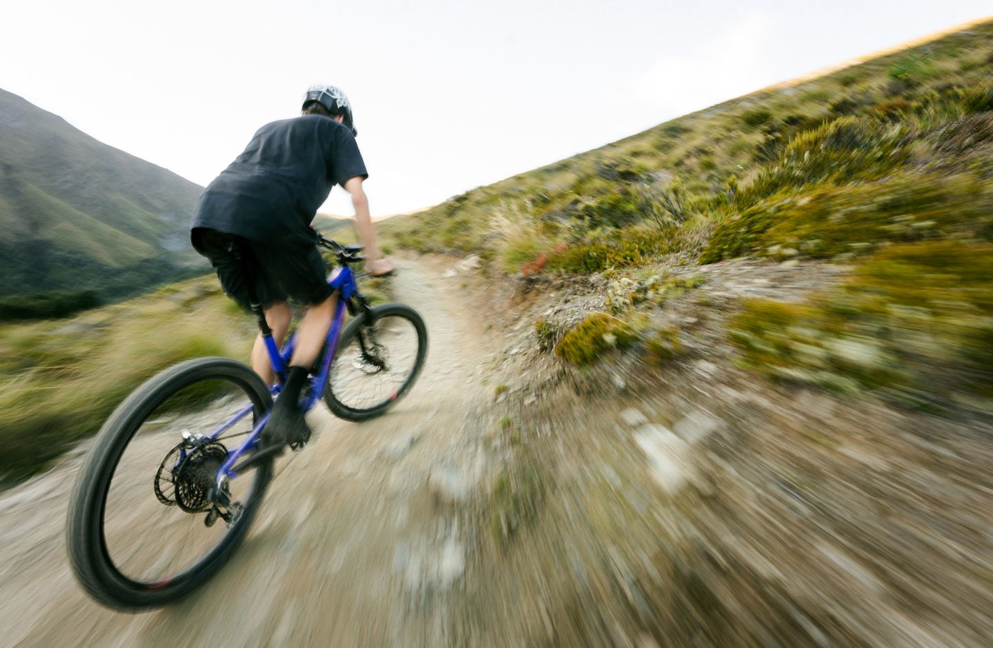 Ben Hildred climb his bike on an alpine trail