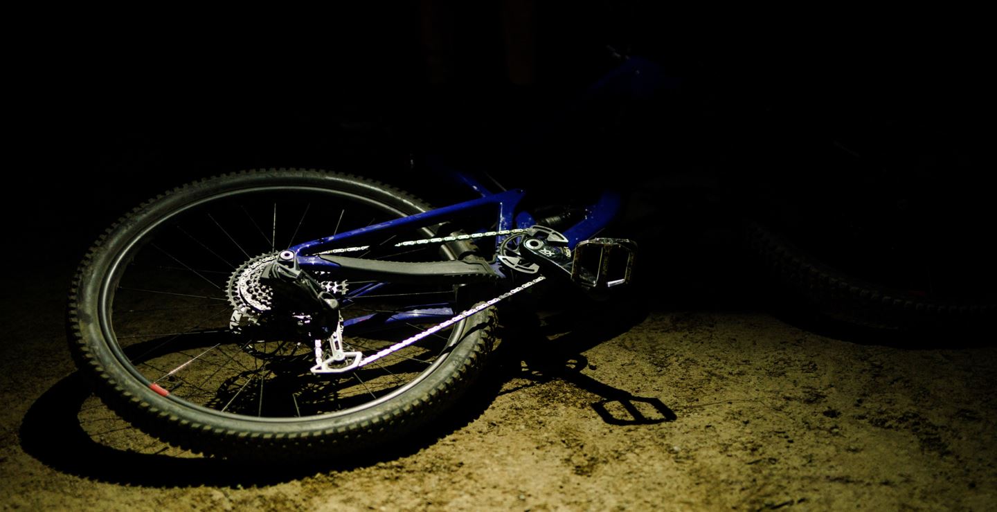 A bike lays on the road in the dark