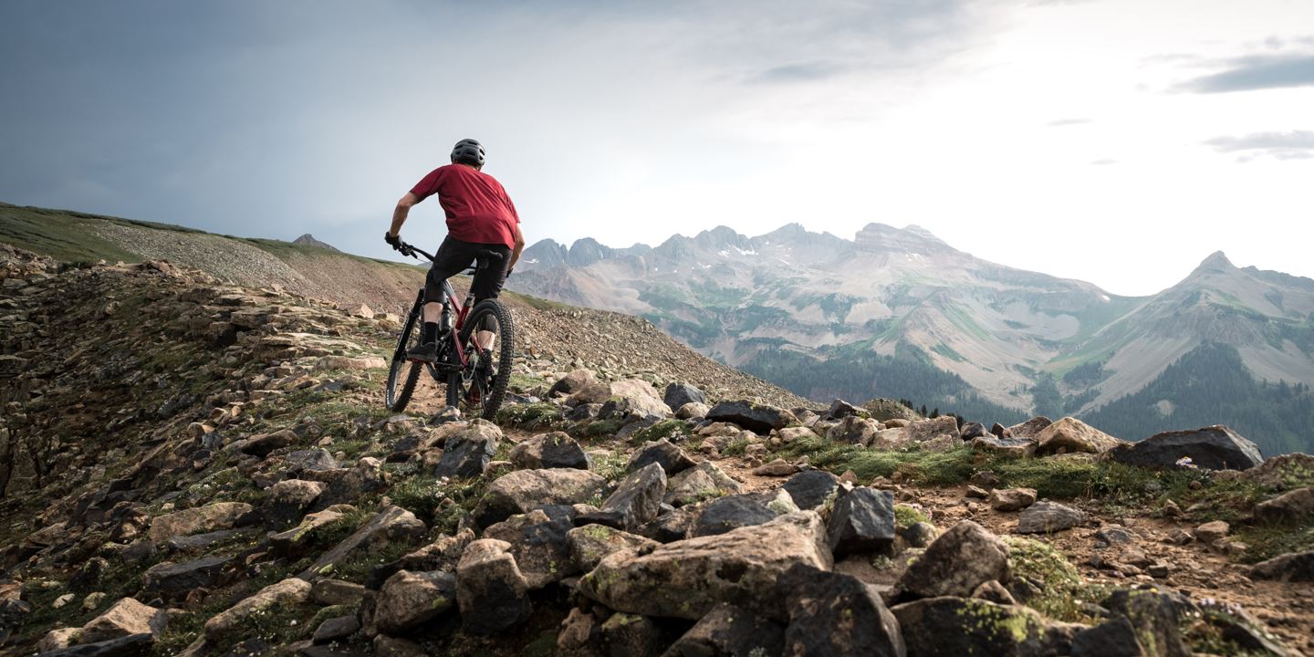 Rider on rocky ridgeline riding Flight Attendant bike