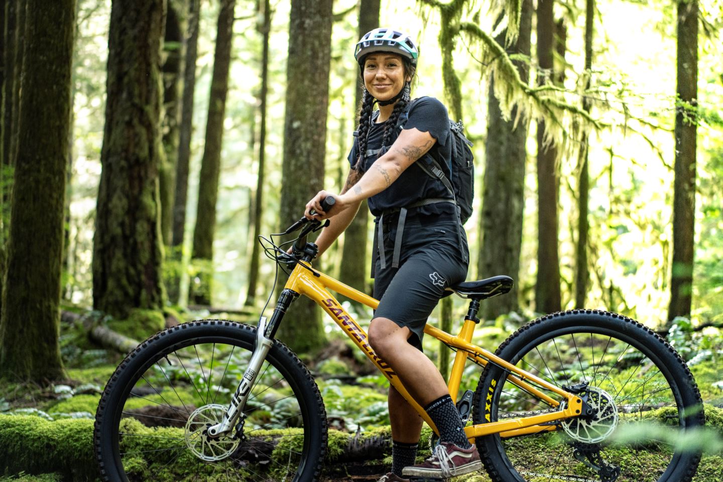 Myia Antone in a bike helmet with her bike in the woods