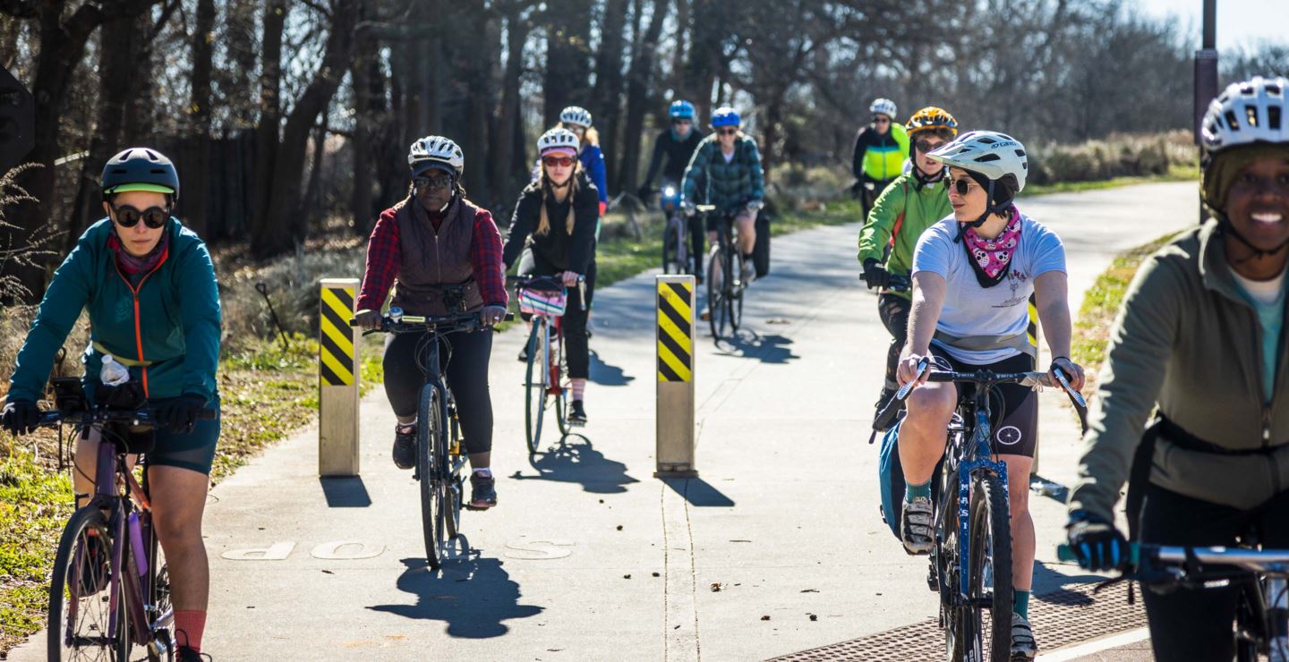 A group of cyclist approach a road.