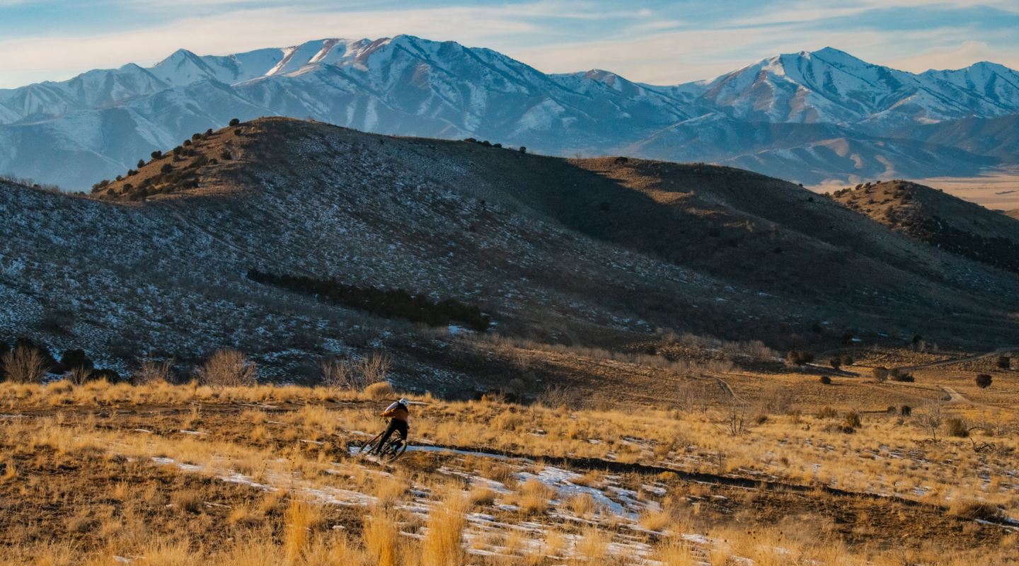 Garrin Evan shredding singletrack with Wasatch mountain range in the background.