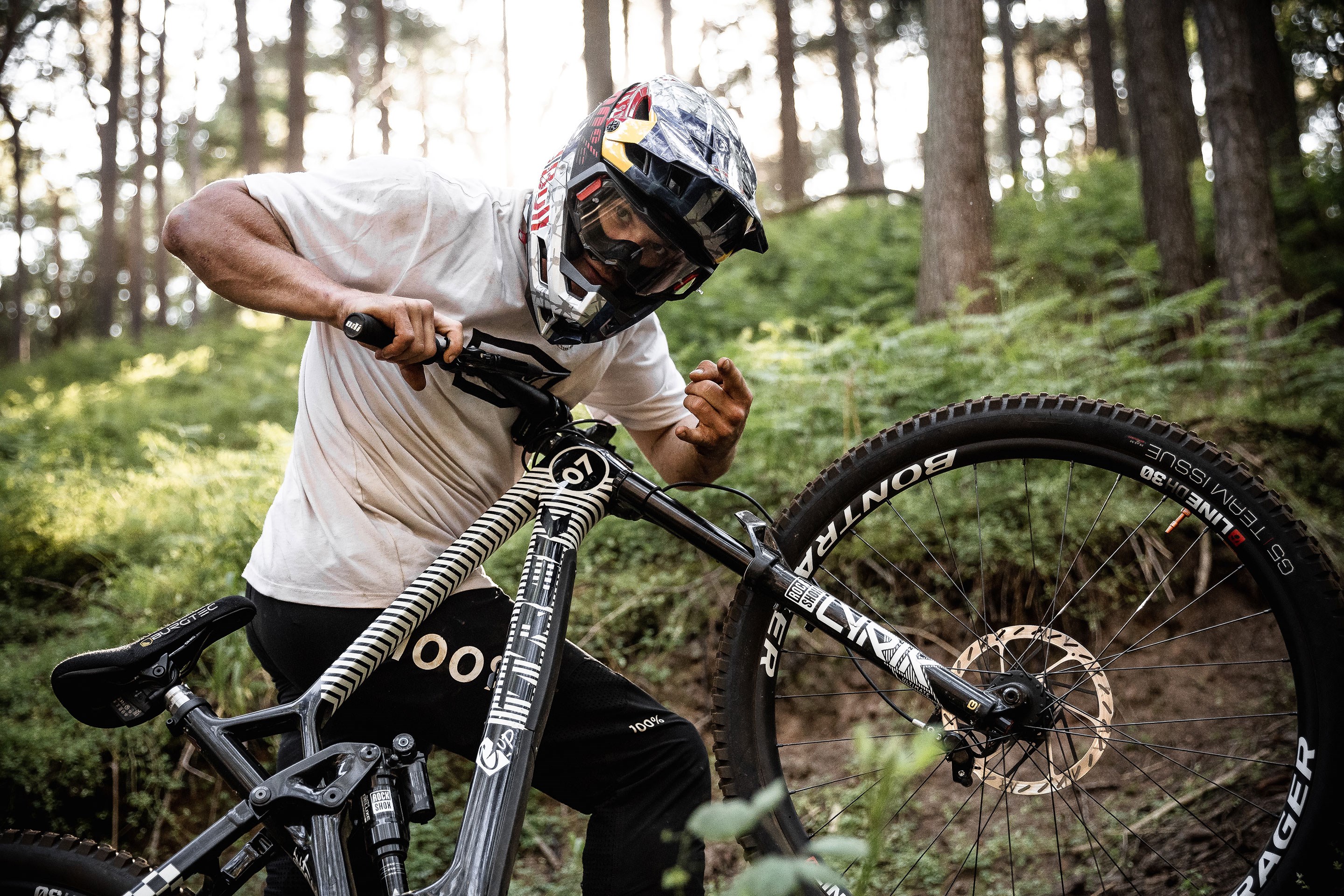 Kade Edwards throwing mini horns at the camera wile pushing his Fuel EX up the trail.