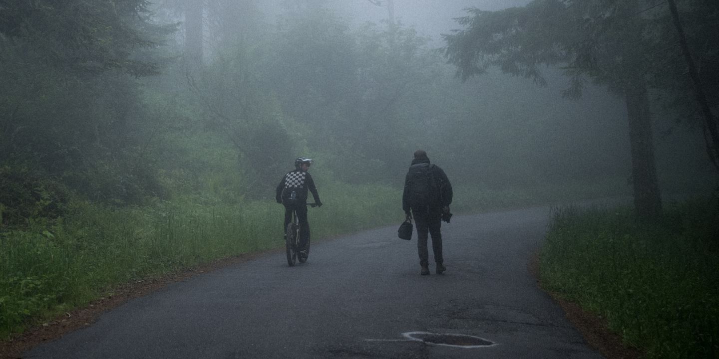 Ryan Howard and Nic Genovese riding and walking away in the foggy mist.