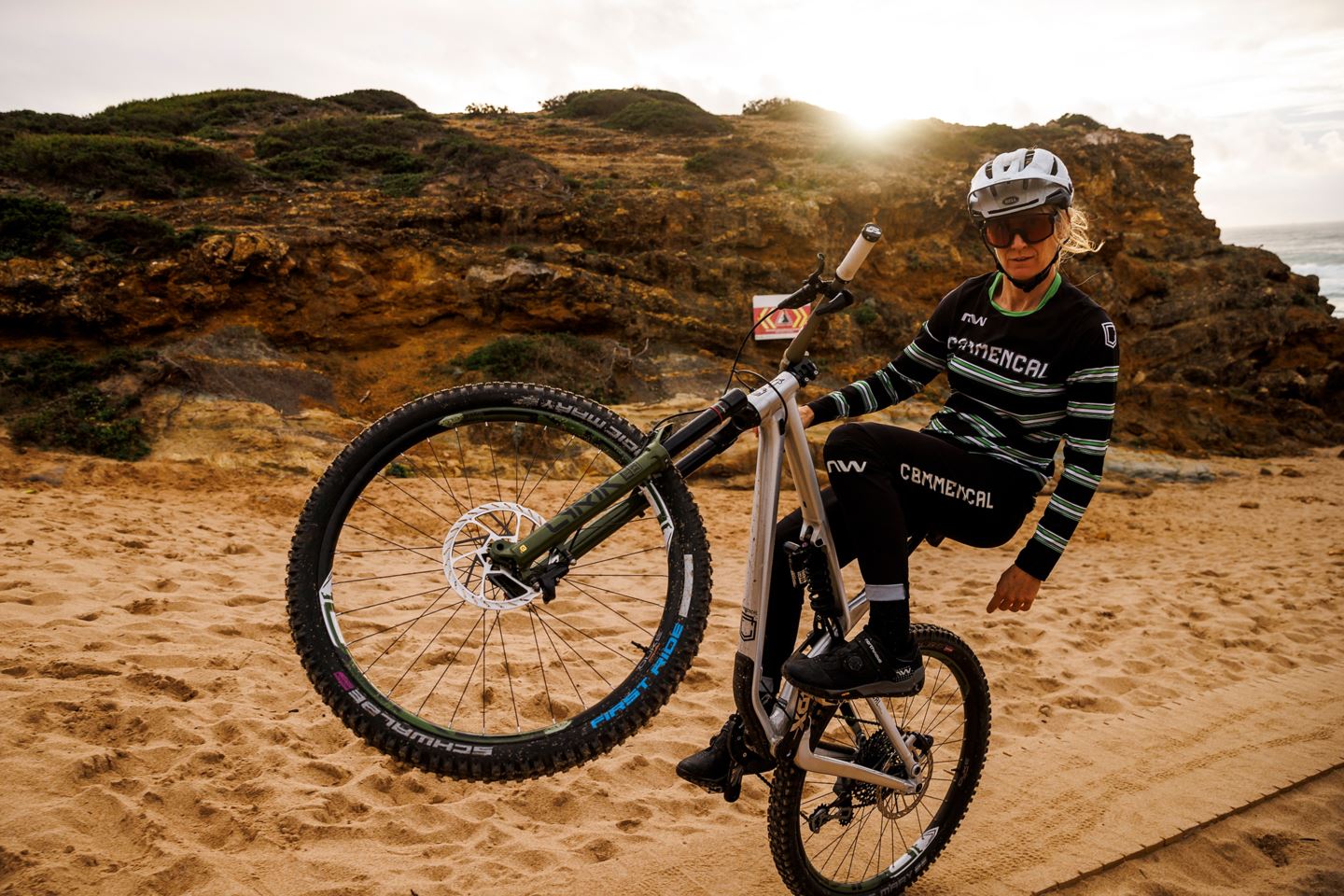 Cécile Ravanel riding a one-handed wheelie on the beach.