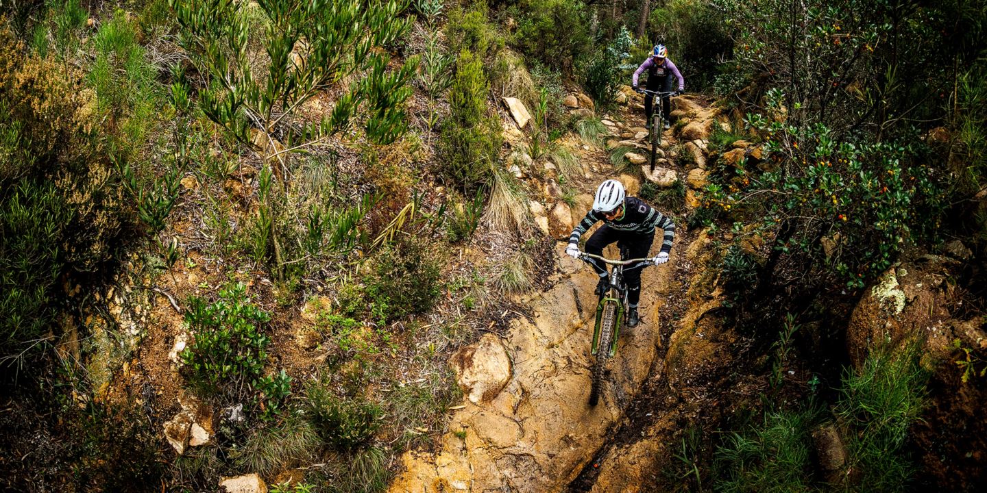 Cécile Ravanel and Vali Höll riding down a technical trail in Sintra, Portugal.