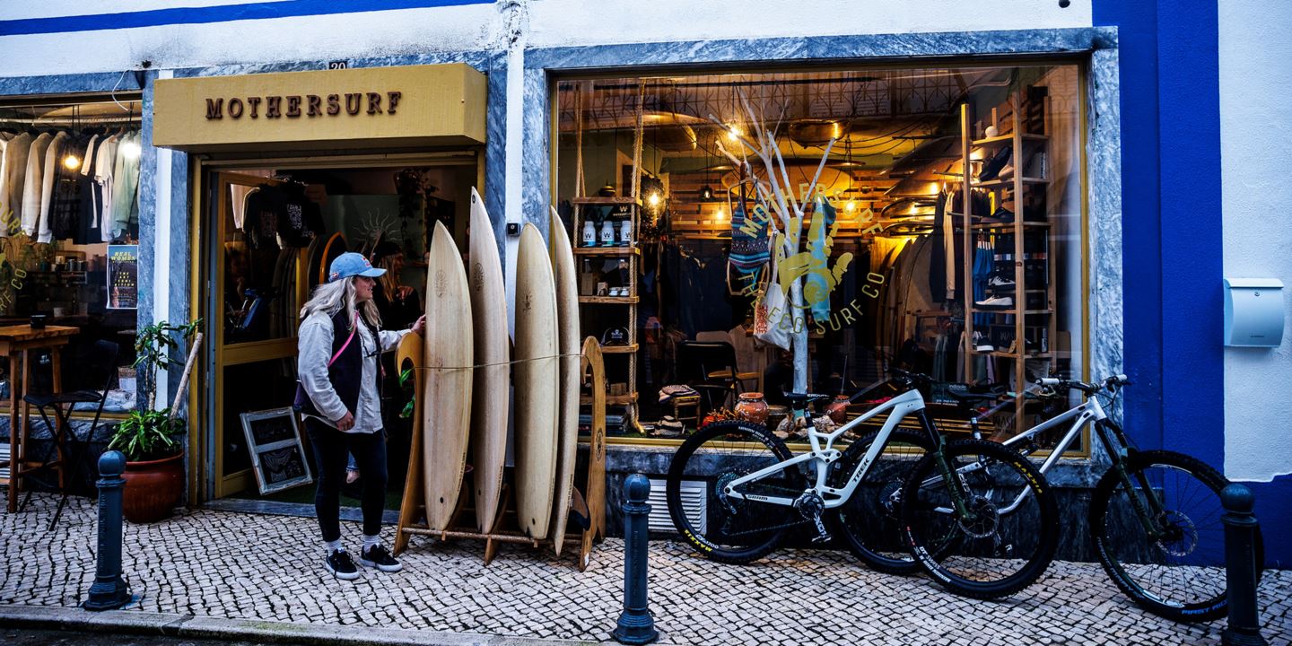 Vali Höll standing next to surf boards outside a shop.