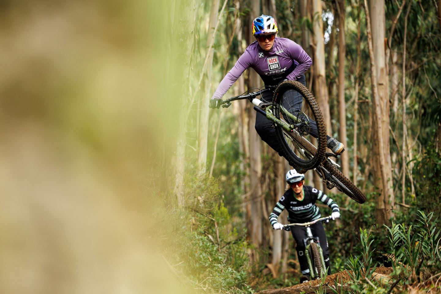 Vali Höll sending it off of a natural feature with Cécile Ravanel trailing behind her.