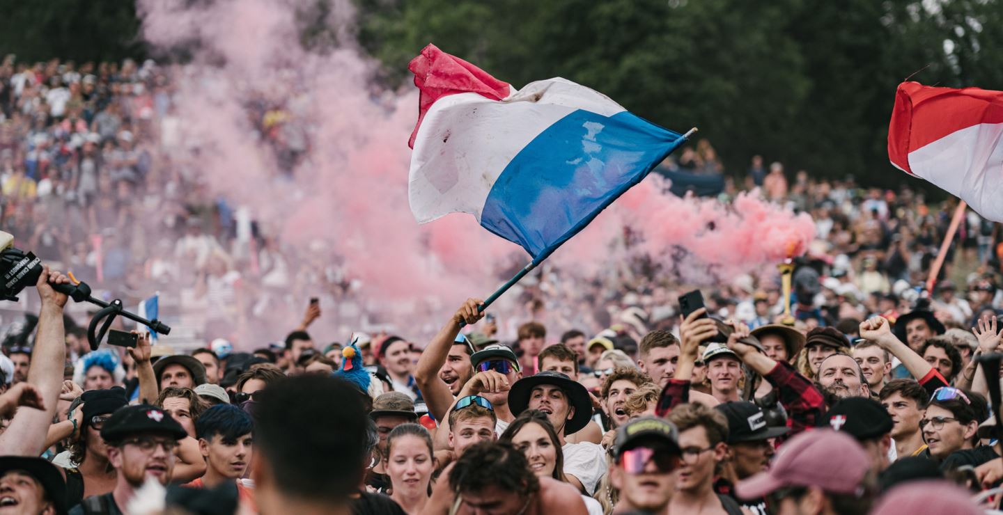 A French flag is waved above the crowd