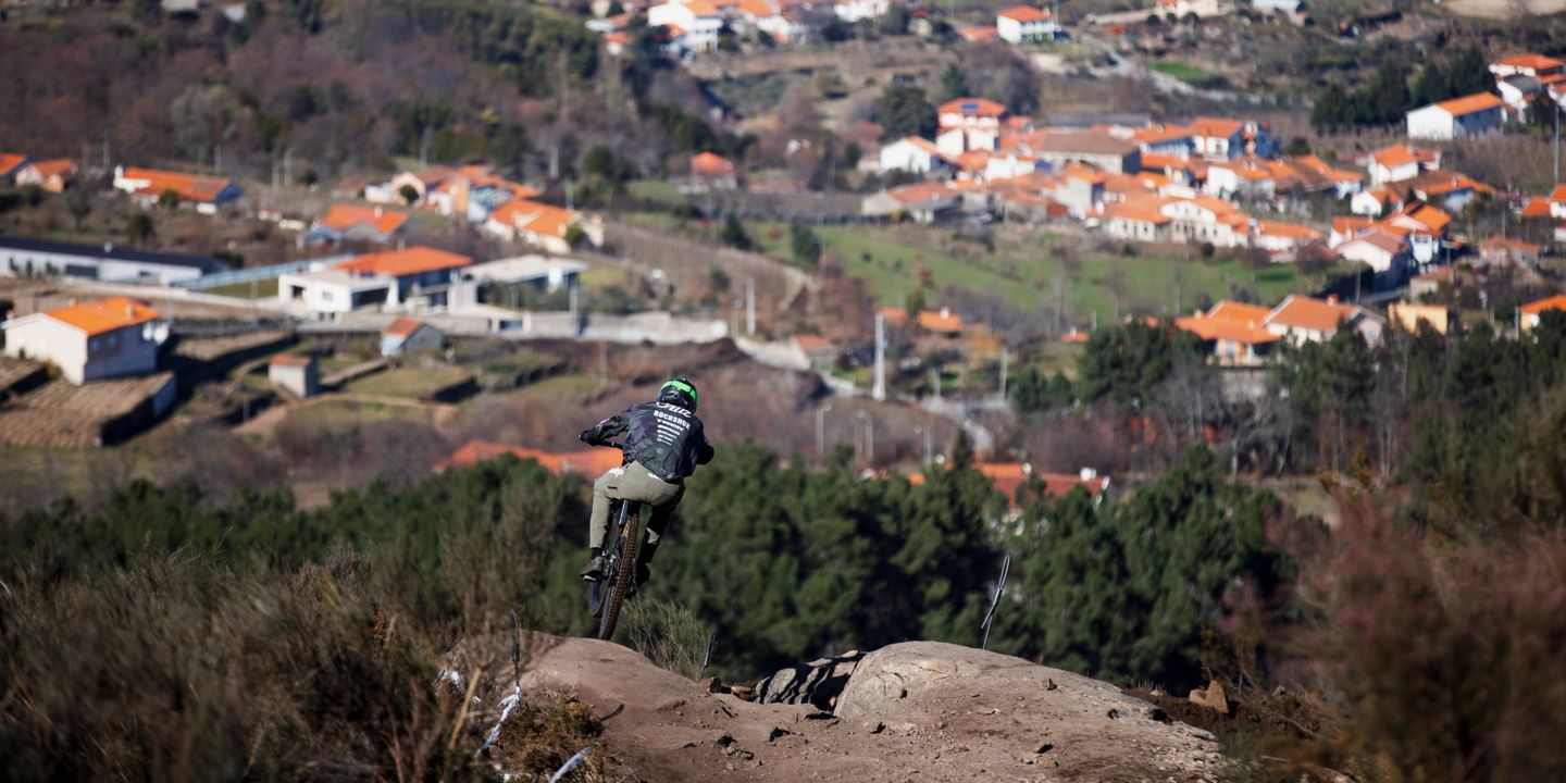 Tegan Cruz riding down the DH course with terracotta roofs in the background.