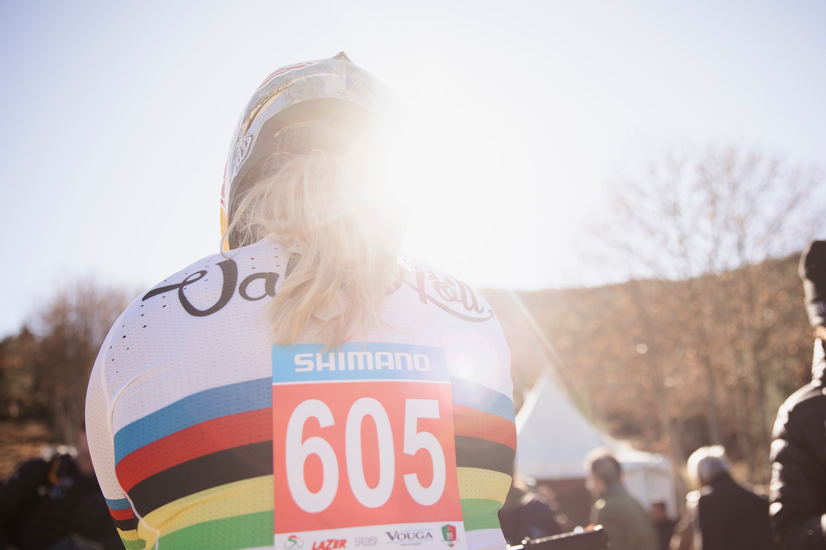 Backlit sunflare shot of Vali Höll in her white World Champion jersey.