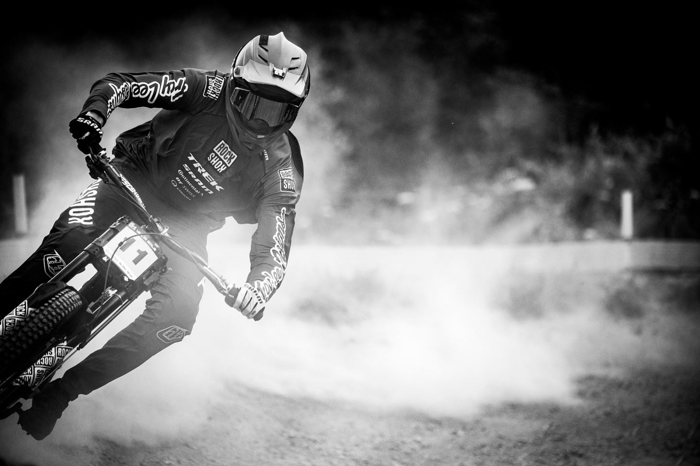 A black and white photo of Tegan coming out of a dusty berm.