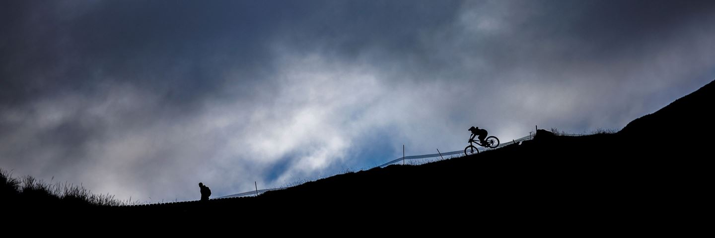 A moody picture of Vali Höll riding down the ridgeline on the DH track in Fort William, Scotland.