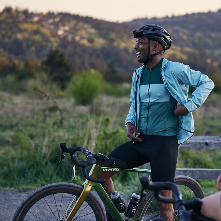 A rider smiles while taking a break during a gravel ride.